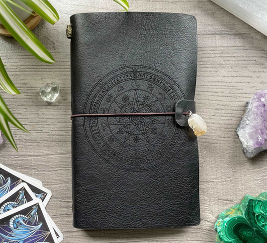 Pictured is a faux leather refillable notebook with a crystal. Faux Leather Spiritual Symbols Refillable Notebook (Black) front