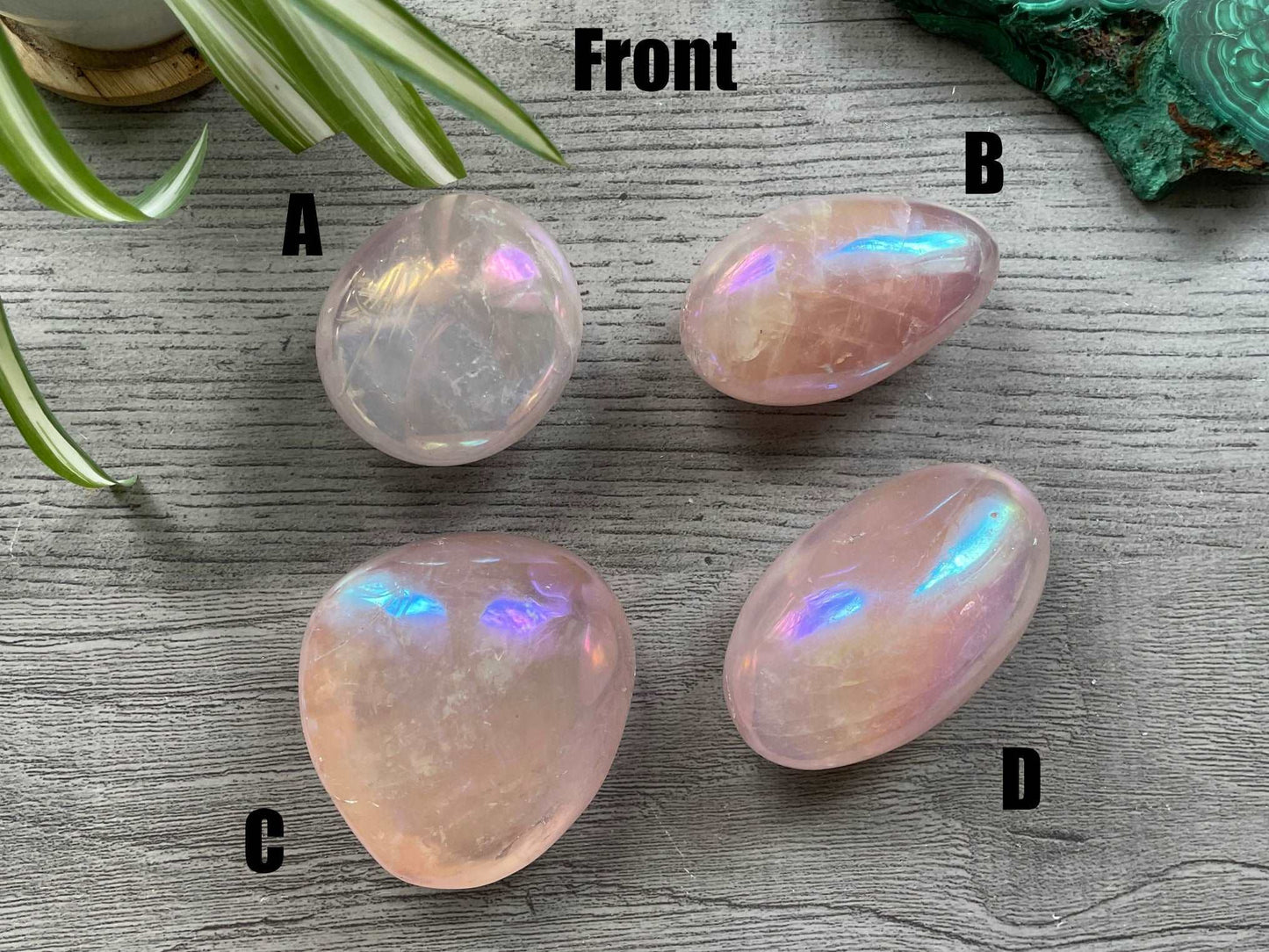 Pictured are various polished aura rose quartz palm stones. Aura Rose Quartz Palm Stone front