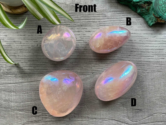 Pictured are various polished aura rose quartz palm stones. Aura Rose Quartz Palm Stone front