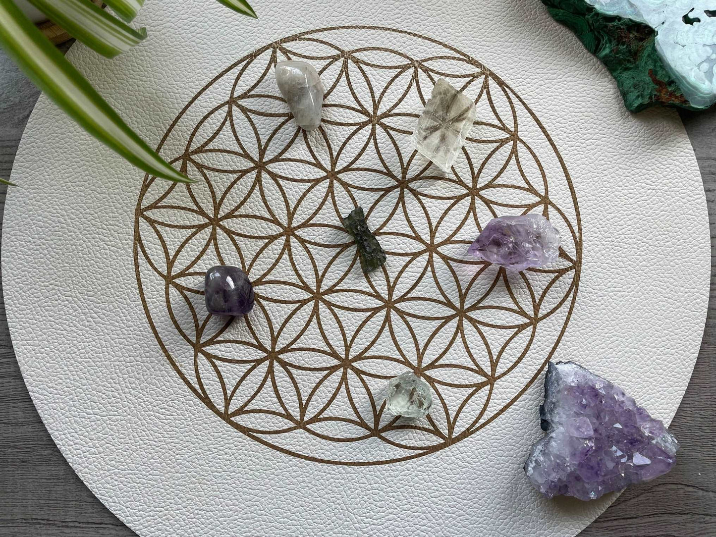 Pictured is a faux leather flower of life crystal grid. Flower of Life Vegan Leather Crystal Grid