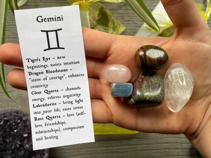 An image of a collection of tumbled stones in an organza bag. To the side is a piece of paper that describes what each tumbled stone's metaphysical properties are. GEMINI Zodiac Tumbled Crystal Bag crystals