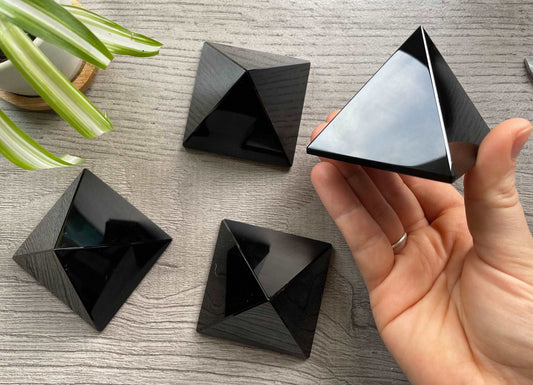 Pictured are various pyramids carved out of black obsidian. Black Obsidian Crystal Pyramid - The Wandering Fox Emporium, Your Crystal Store