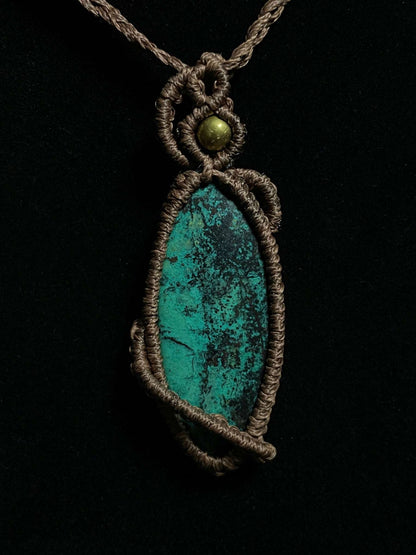 Pictured is a chrysocolla cabochon wrapped in macrame thread. A gothic book and flowers are nearby. Chrysocolla Macramé Necklace (Twisted Nightshade Jewellery) - The Wandering Fox Emporium, Your Crystal Store black