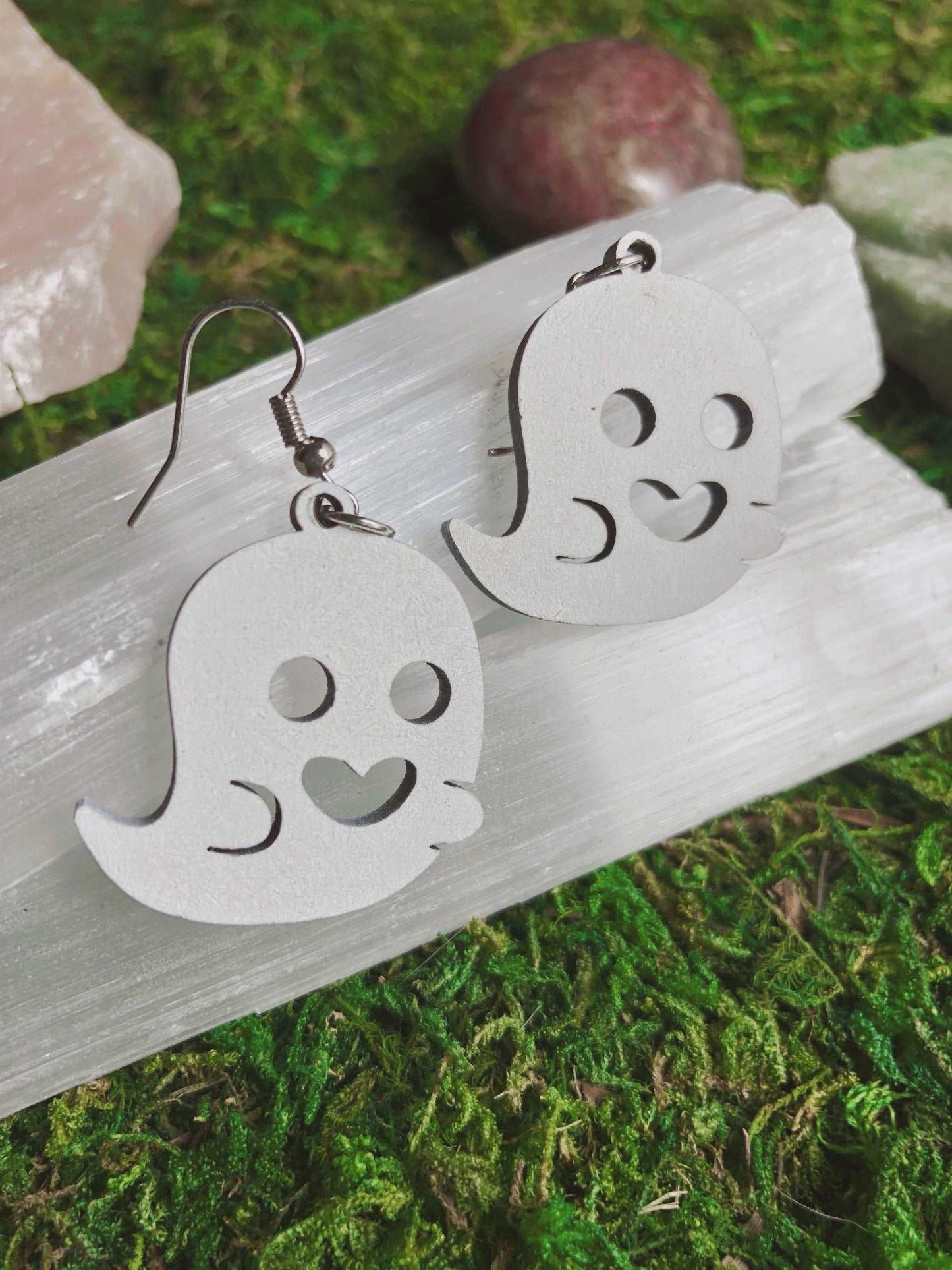 Pictured is a pair of earrings featuring a cute white ghost. They are made of wood.  Cute Ghost Earrings