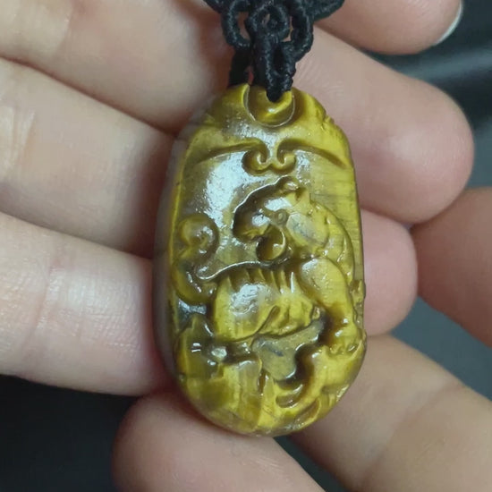 A picture of a tiger pendant carved out of tiger's eye stone. The pendant is on an intricate black macrame necklace. Tiger's Eye Tiger Macramé Necklace (Twisted Nightshade Jewellery) - The Wandering Fox Emporium, Your Crystal Store video