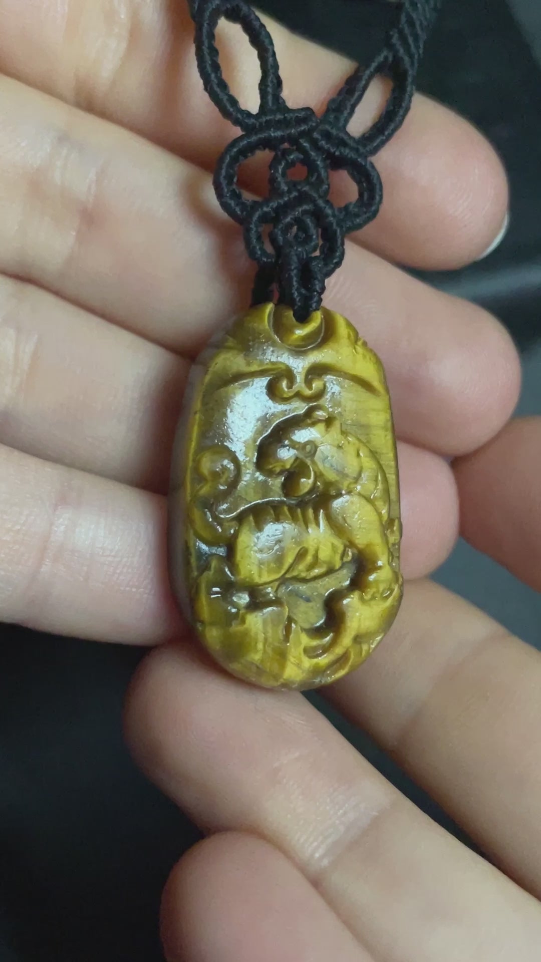 A picture of a tiger pendant carved out of tiger's eye stone. The pendant is on an intricate black macrame necklace. Tiger's Eye Tiger Macramé Necklace (Twisted Nightshade Jewellery) - The Wandering Fox Emporium, Your Crystal Store video