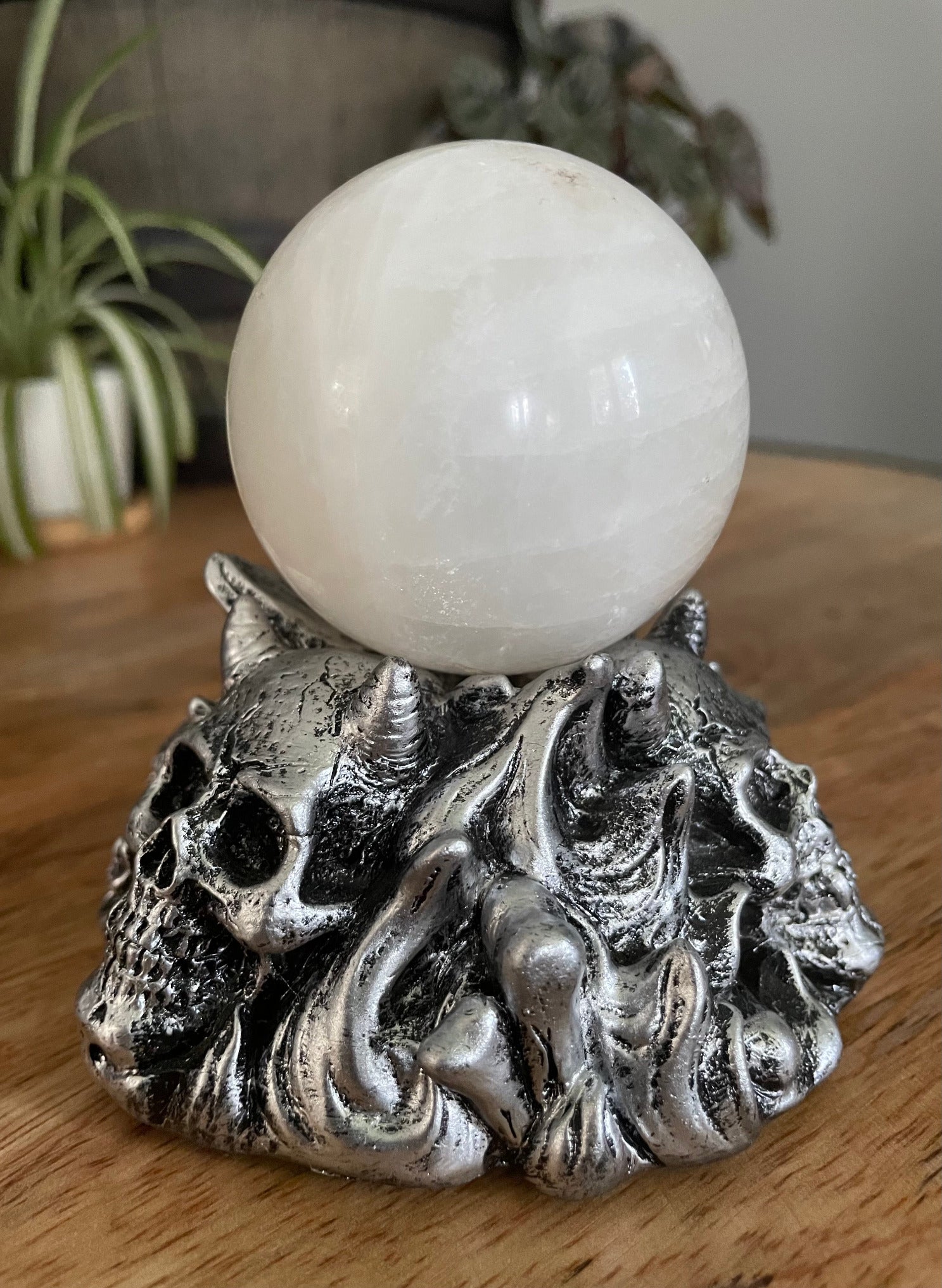 Pictured is a silver resin sphere holder with various demon skulls on it. Horned Demon Skulls Crystal Sphere Stand side 2