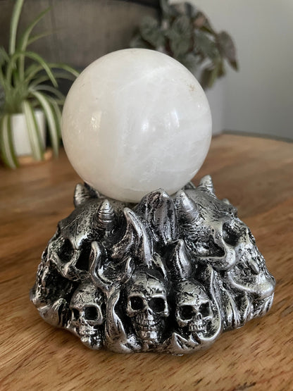 Pictured is a silver resin sphere holder with various demon skulls on it. Horned Demon Skulls Crystal Sphere Stand side