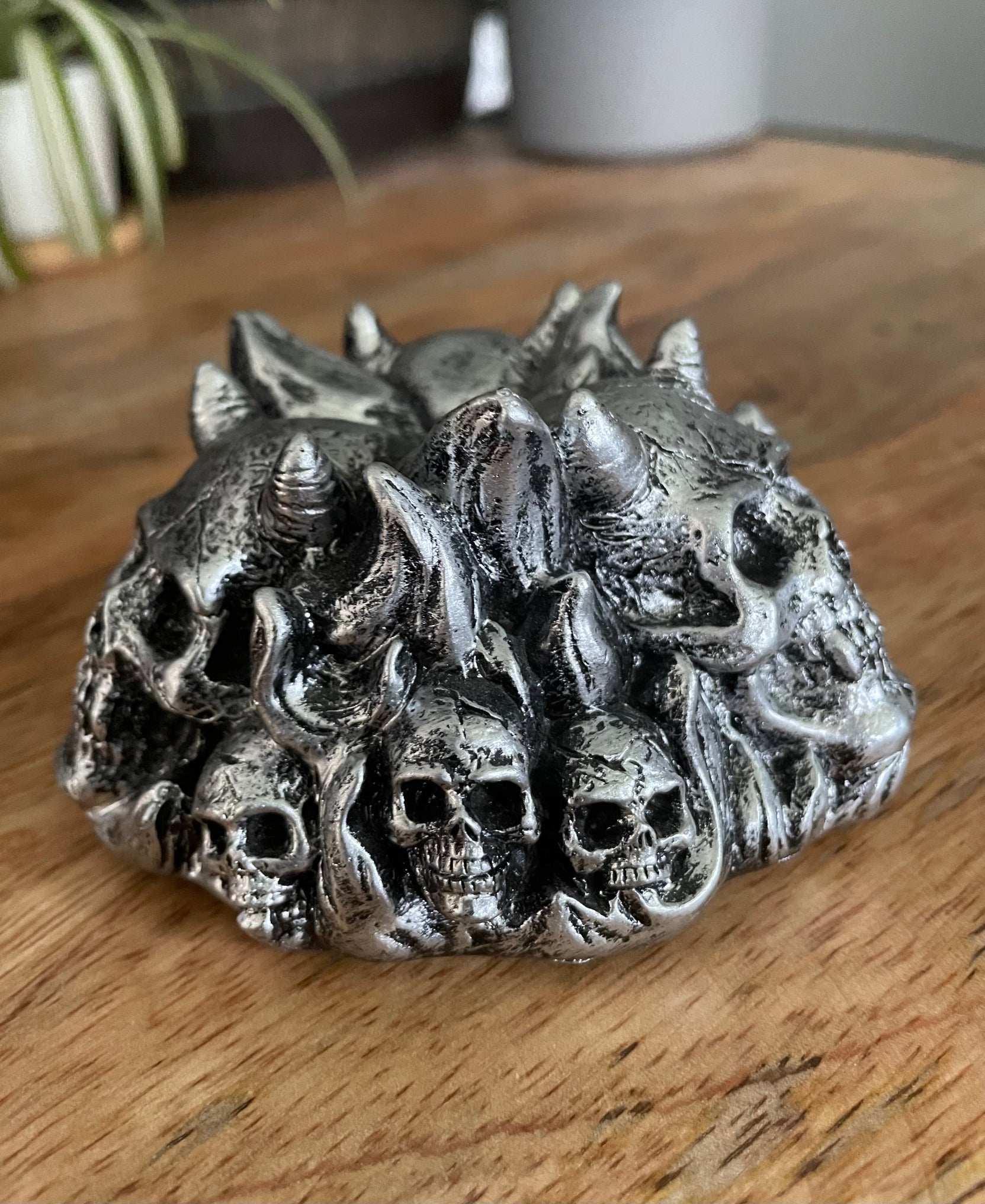 Pictured is a silver resin sphere holder with various demon skulls on it. Horned Demon Skulls Crystal Sphere Stand back