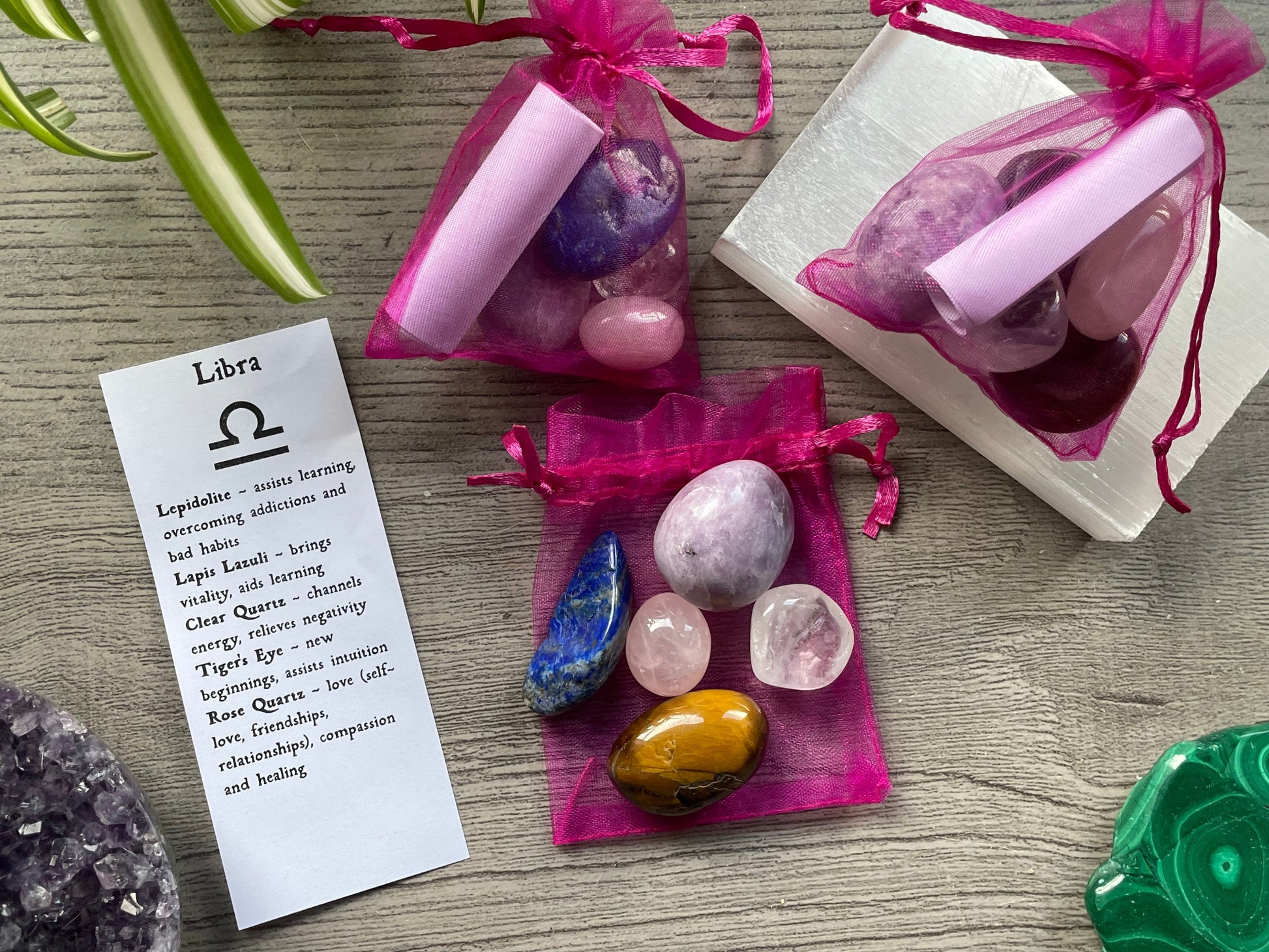 An image of a collection of tumbled stones in an organza bag. To the side is a piece of paper that describes what each tumbled stone's metaphysical properties are. LIBRA Zodiac Tumbled Crystal Bag