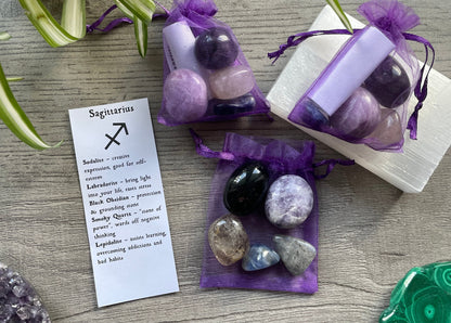 An image of a collection of tumbled stones in an organza bag. To the side is a piece of paper that describes what each tumbled stone's metaphysical properties are. SAGITTARIUS Zodiac Tumbled Crystal Bag 