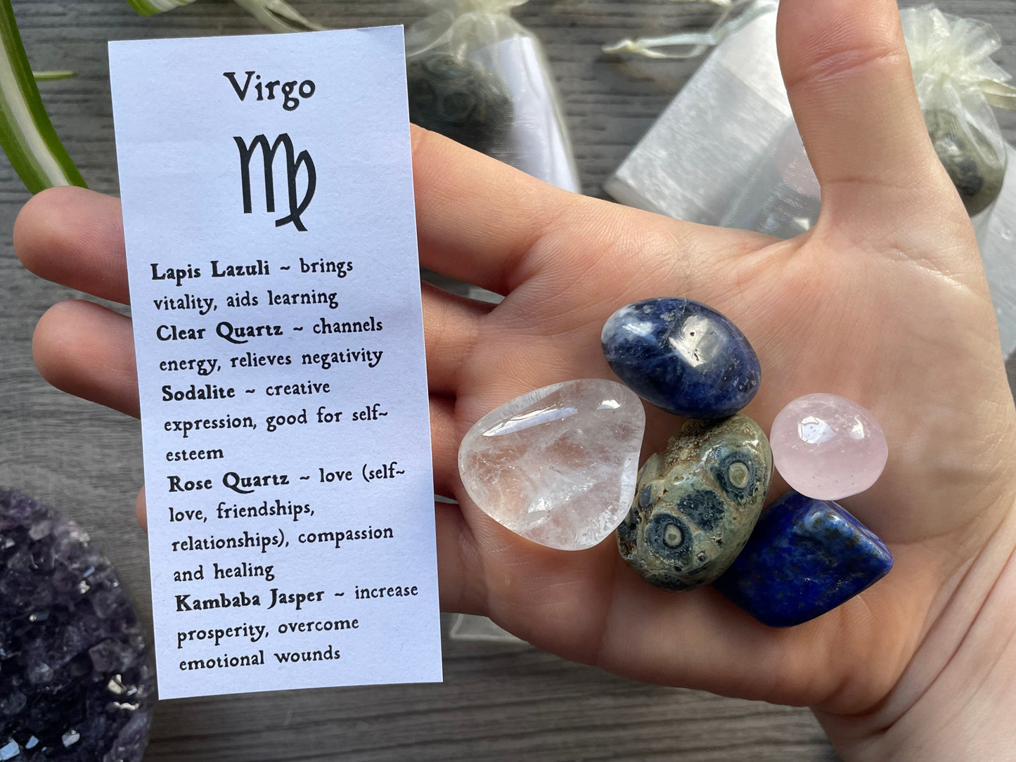 An image of a collection of tumbled stones in an organza bag. To the side is a piece of paper that describes what each tumbled stone's metaphysical properties are. VIRGO Zodiac Tumbled Crystal Bag crystals