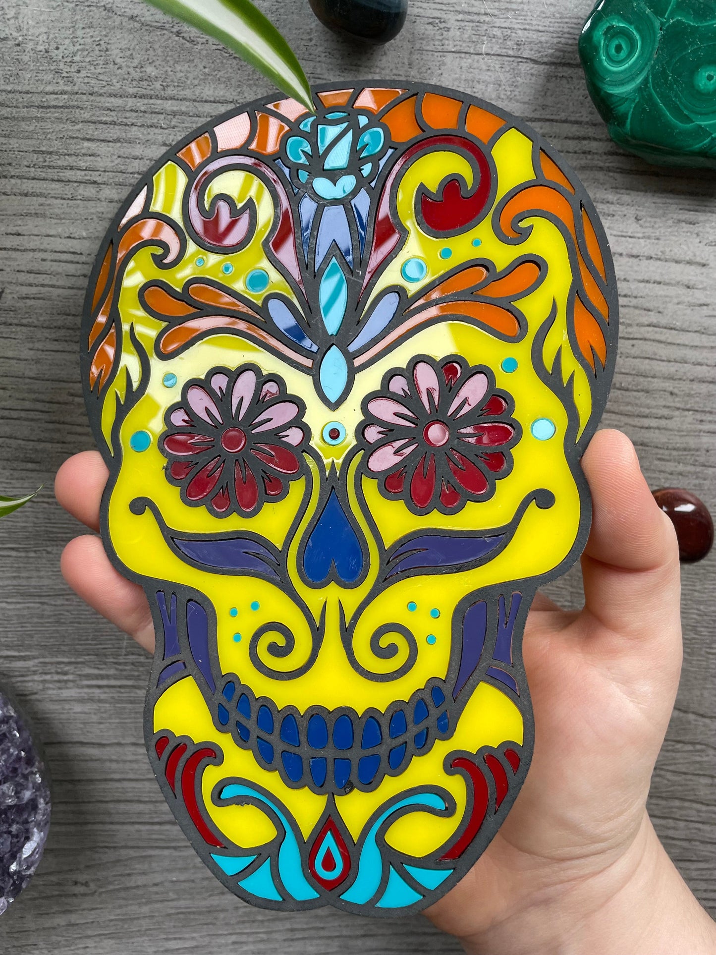 Pictured is a faux stained glass sugar skull made out of wood and acrylic. Sugar Skull Wall Art (Yellow) close up