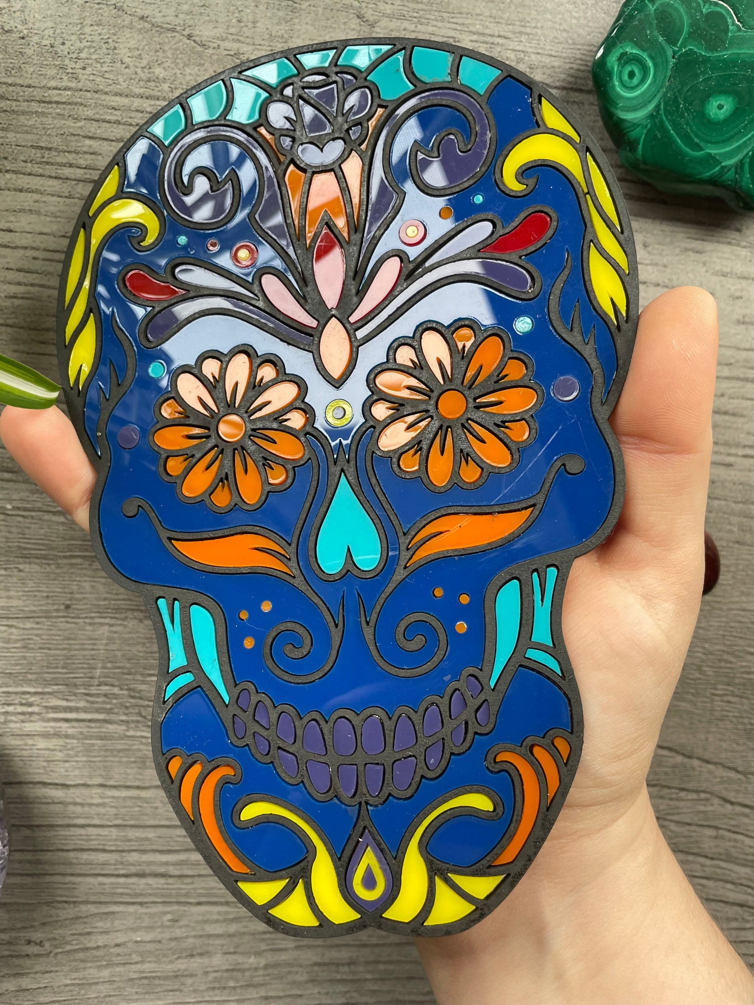 Pictured is a faux stained glass sugar skull made out of wood and acrylic. Sugar Skull Wall Art (Blue)  close up