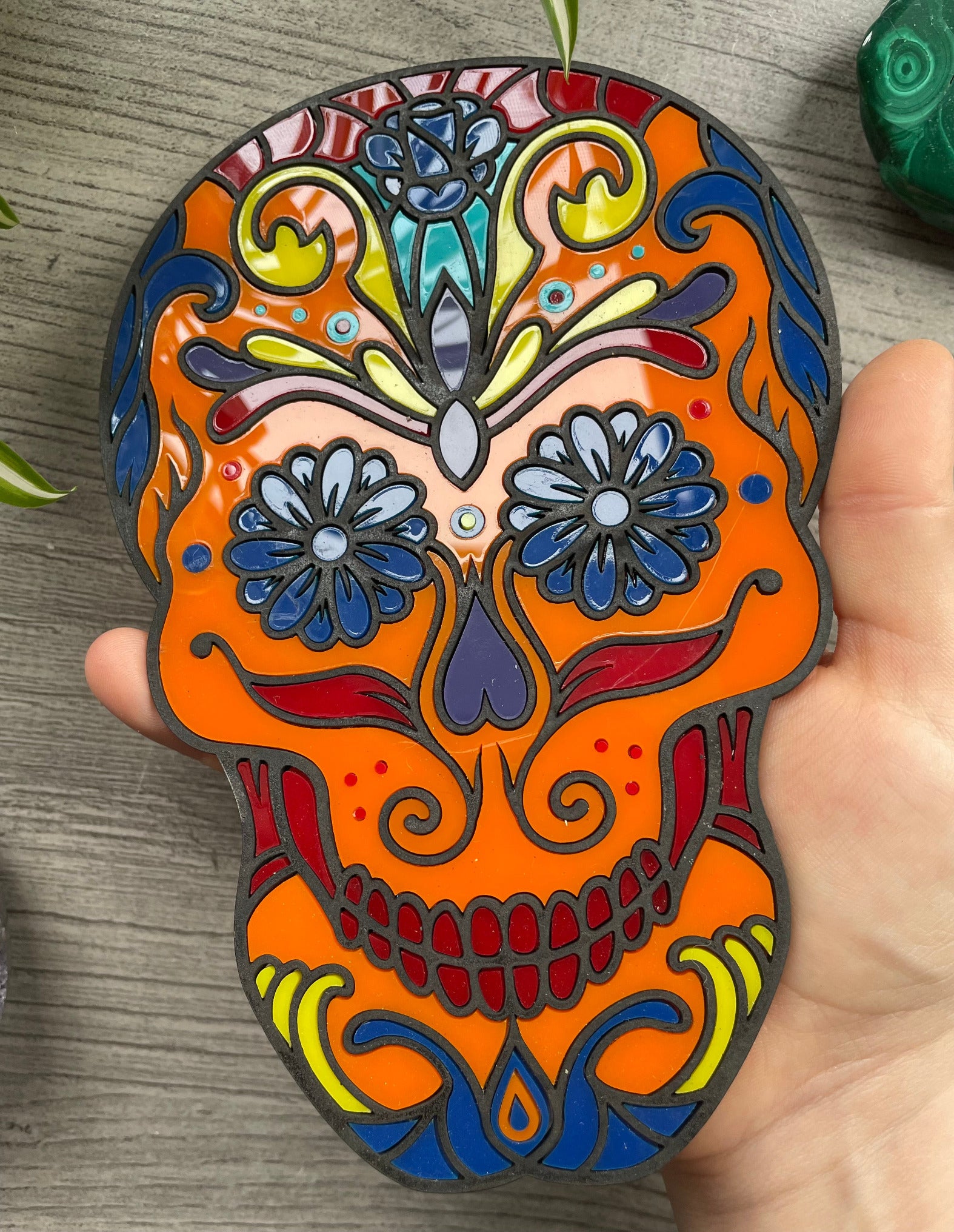 Pictured is a faux stained glass sugar skull made out of wood and acrylic. Sugar Skull Wall Art (Orange) close up