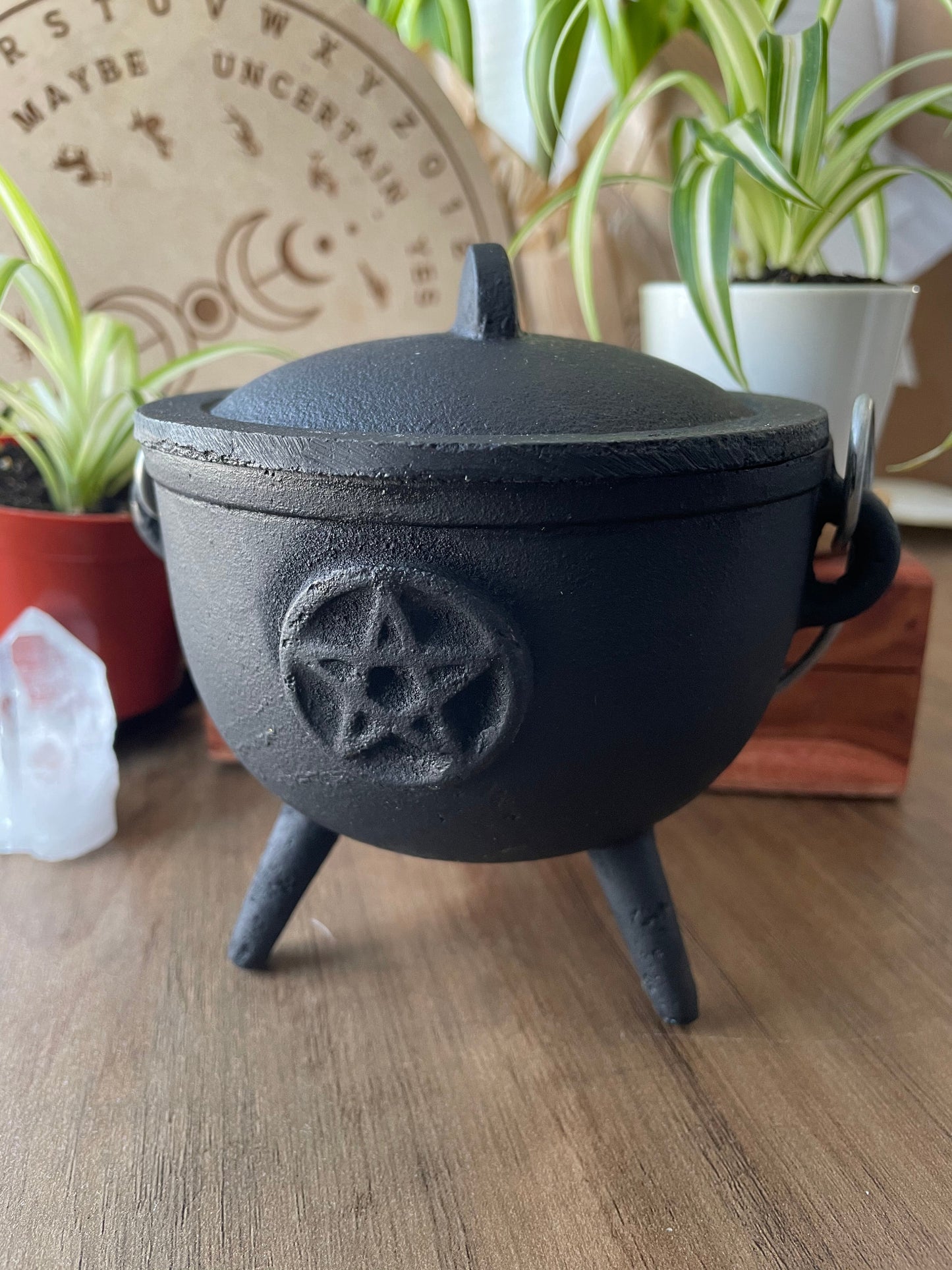 Pictured is a cast iron cauldron with lid. Pentacle Cast Iron Cauldron 12cm