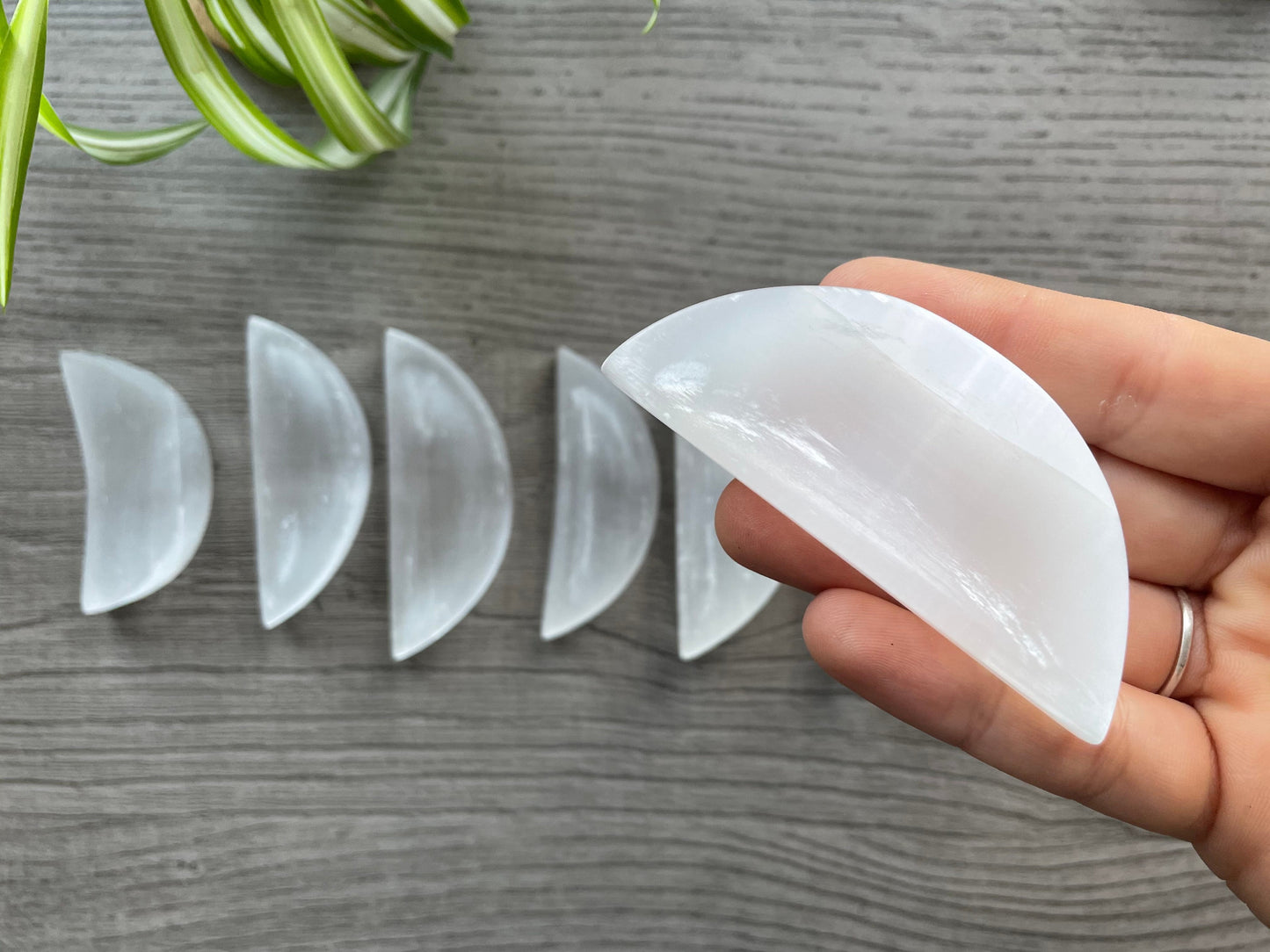 Pictured is a crescent-shaped bowl carved out of selenite. Mini Selenite (Satin Spar) Crystal Moon Bowls  close up