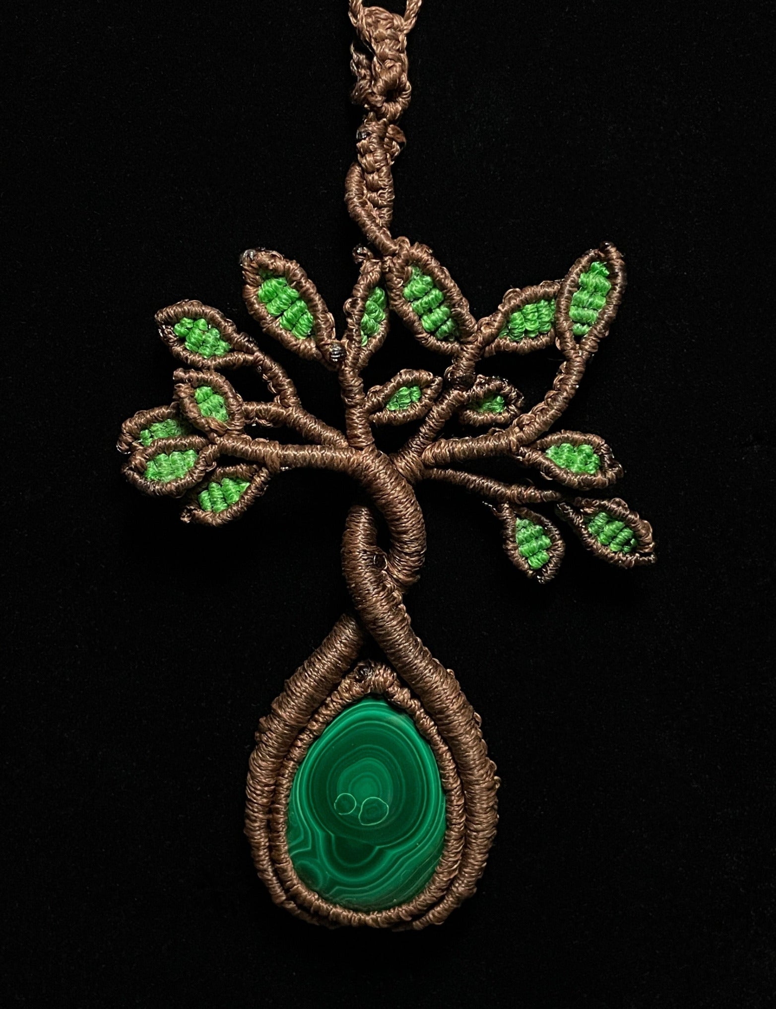 A handmade macrame necklace featuring a tree design with a malachite cabochon as its centerpiece. Malachite Tree of Life Macramé Necklace (Twisted Nightshade Jewellery) - The Wandering Fox Emporium, Your Crystal Store black