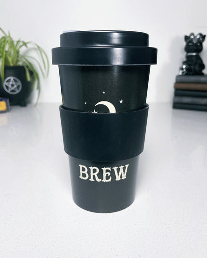 A black eco travel mug with a white words that say "Witches Brew" on the side. "Witches Brew" Eco Travel Mug sleeve