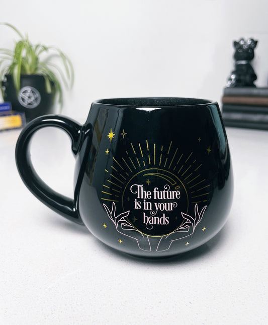 Pictured is a black ceramic mug with colour-changing words that say "The future is in your hands". Colour-changing Fortune Ceramic Mug