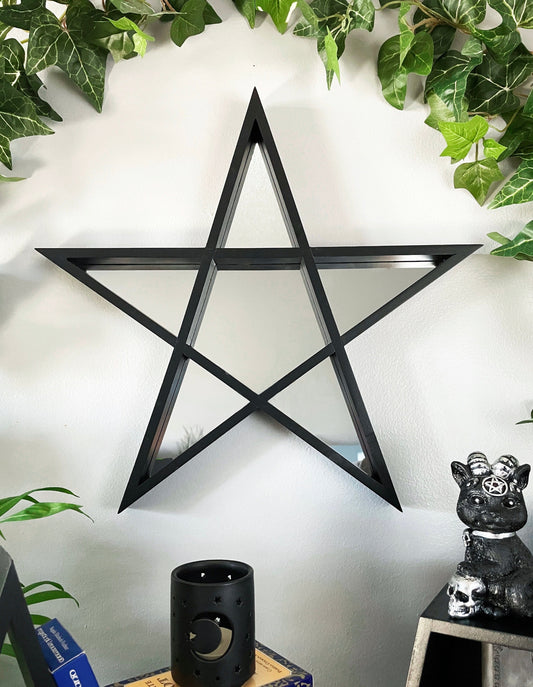 Pictured is a mirror shaped like a pentagram. Pentagram Star Wall Mirror