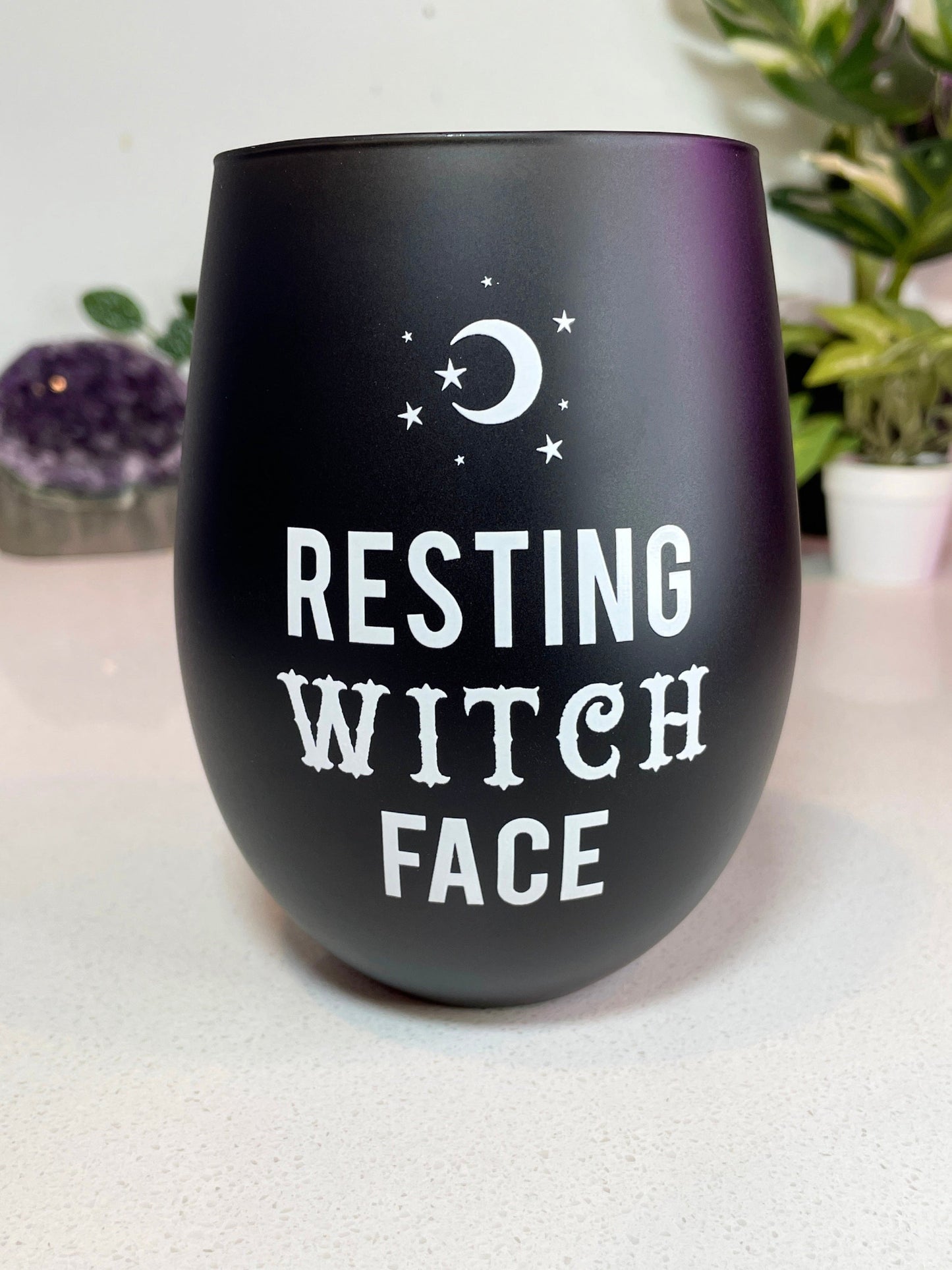 A black stemless wine glass with the words "resting witch face" written on it in white letters. The glass is on a white background. "Resting Witch Face" Stemless Wine Glass front