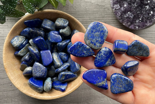 Pictured are various lapis lazuli tumbled stones.