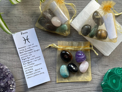 An image of a collection of tumbled stones in an organza bag. To the side is a piece of paper that describes what each tumbled stone's metaphysical properties are. PISCES Zodiac Tumbled Crystal Bag 